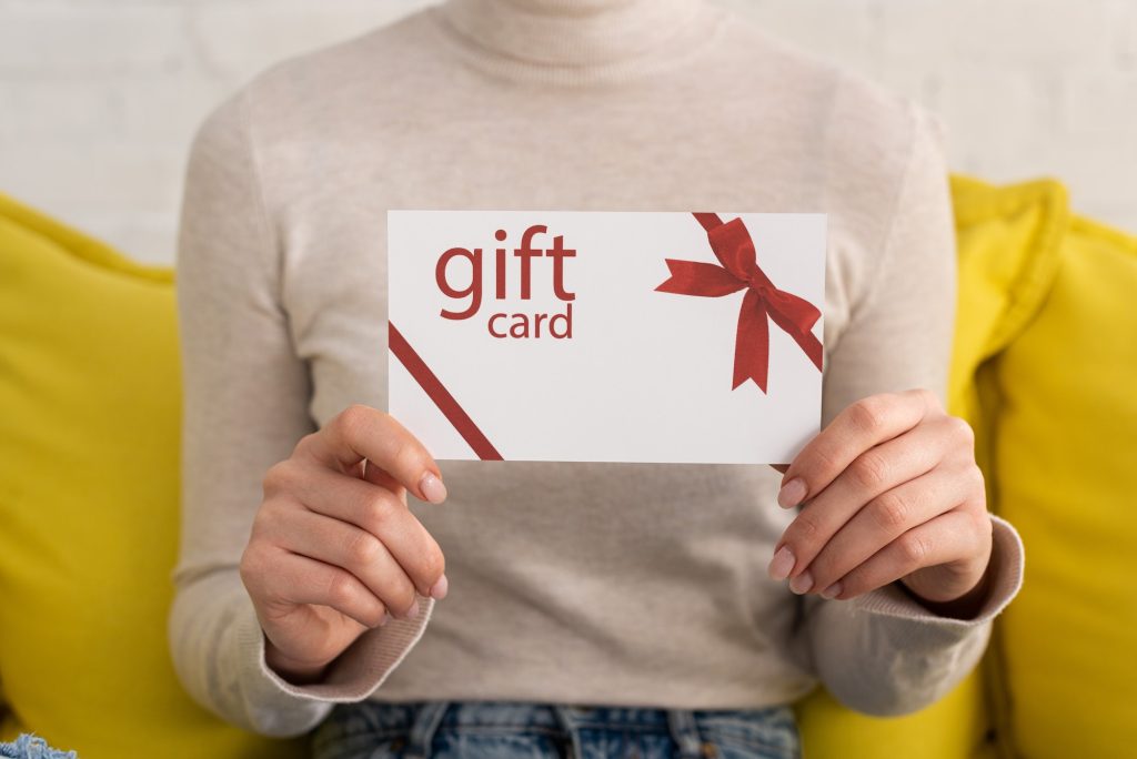 Cropped view of young woman showing gift card